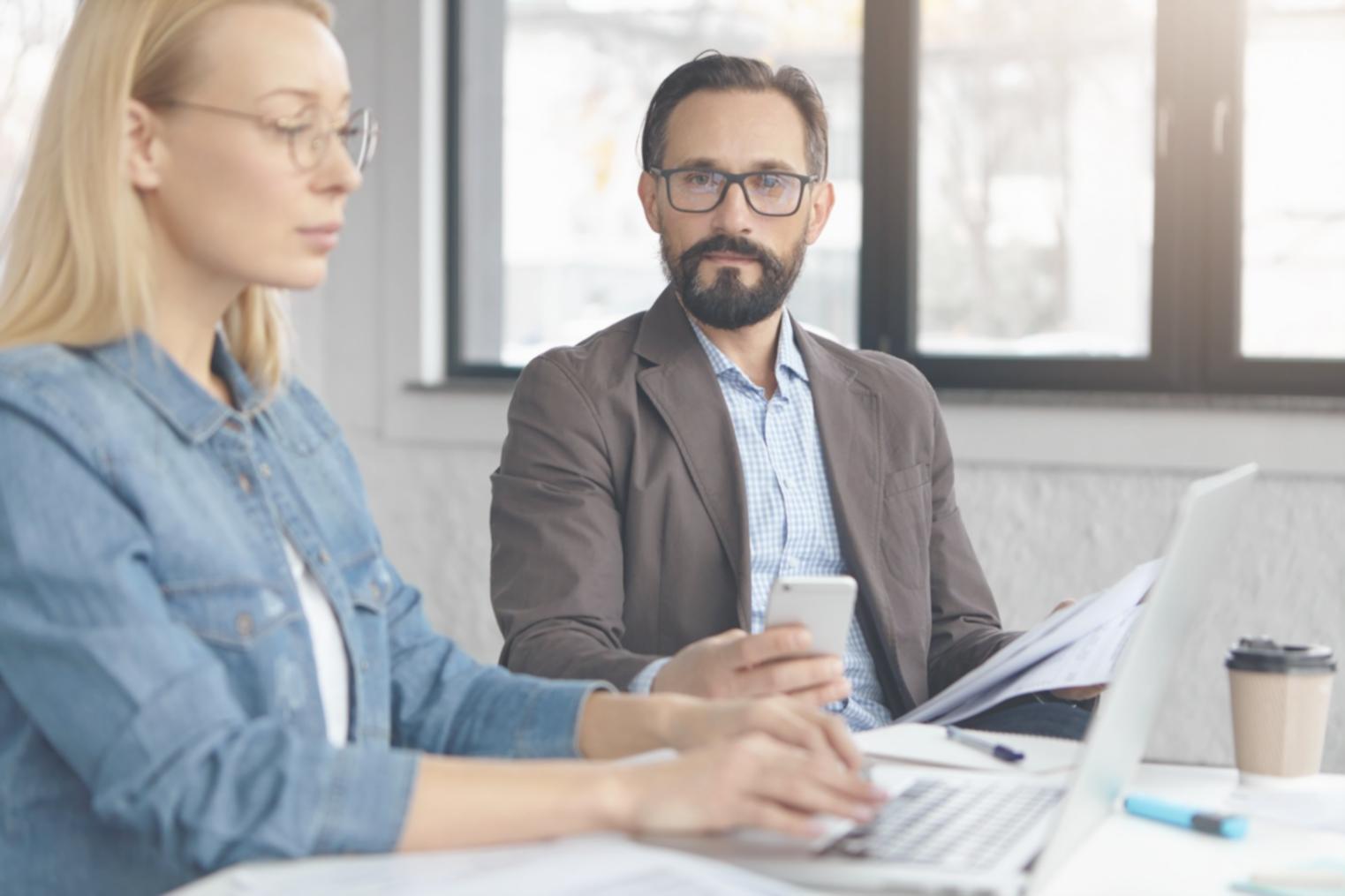 Espace de travail moderne avec plusieurs analystes financiers collaborant sur des projets